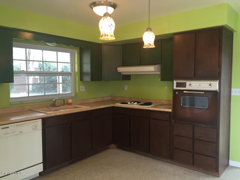 1081 Bali Road Cocoa Beach, FL 32931 - Photo 6 of 17 a kitchen with cabinets a sink and dishwasher