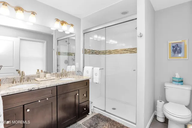 a bathroom with a granite countertop sink mirror and toilet