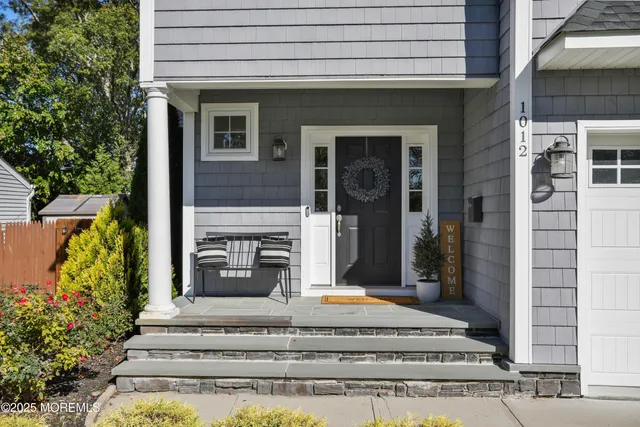 a view of a house with potted plants and a fountain