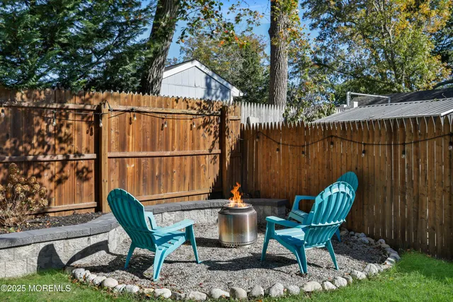 a view of a chairs and table in backyard of the house