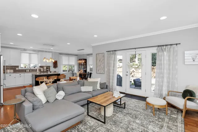 a living room with furniture kitchen view and a large window