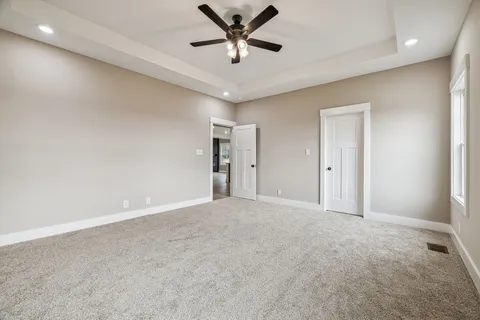 an empty room with closet and a ceiling fan