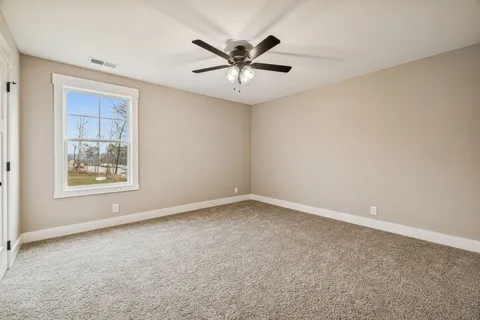 an empty room with a window and a ceiling fan