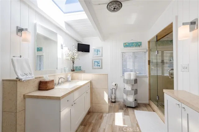 a spacious bathroom with a double vanity sink a mirror and a shower