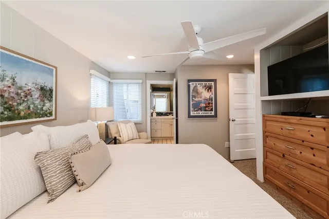 a bedroom with a large bed and a flat screen tv