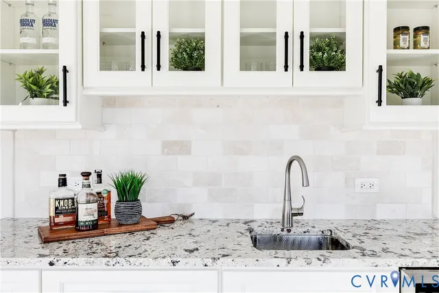 a close view of a sink a faucet a potted plant on a counter top