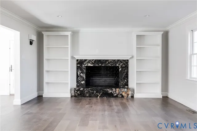 a view of empty room with wooden floor and a window