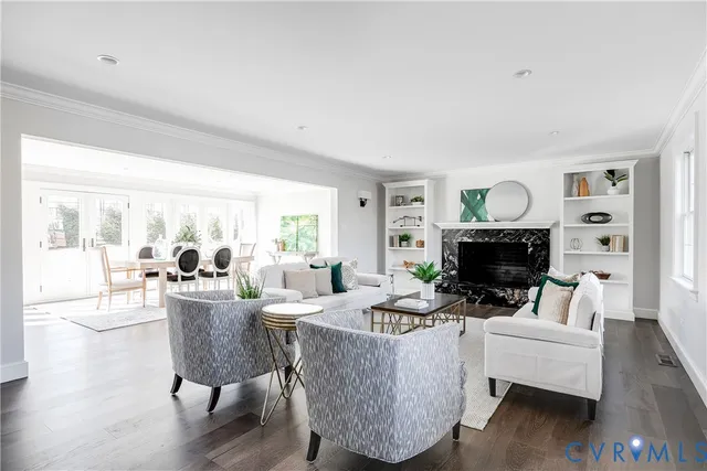 a living room with furniture a fireplace and a large window