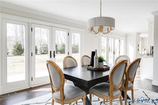 a dining room with furniture a chandelier and wooden floor