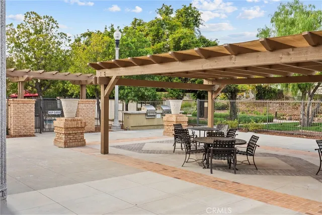 a patio with a table and chairs under an umbrella