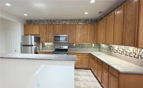 a kitchen with stainless steel appliances granite countertop a sink stove and cabinets
