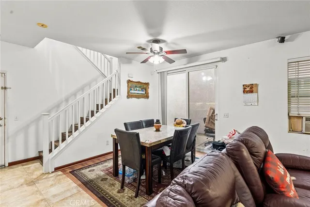 a living room with furniture a dining table and a chandelier