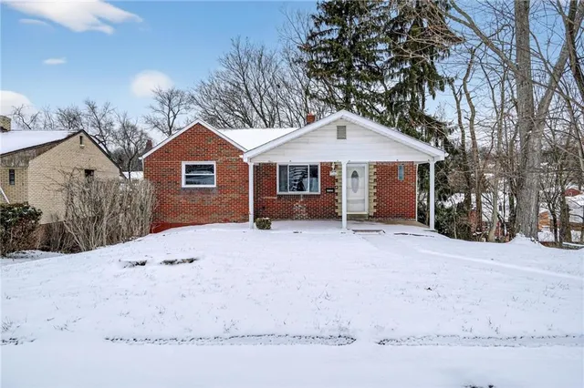 a view of a house with a yard covered in snow