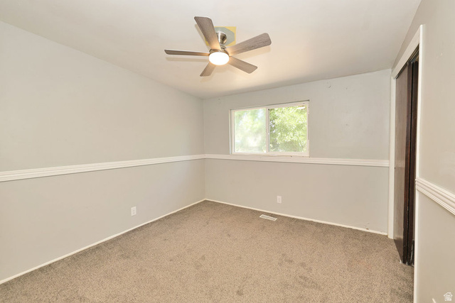 669 Colonial Avenue Layton, UT 84041 - Photo 20 of 51 Ceiling fan with integrated lighting, window with exterior exposure, carpeted flooring, wall trim, and a built-in closet with dark wood-finish doors