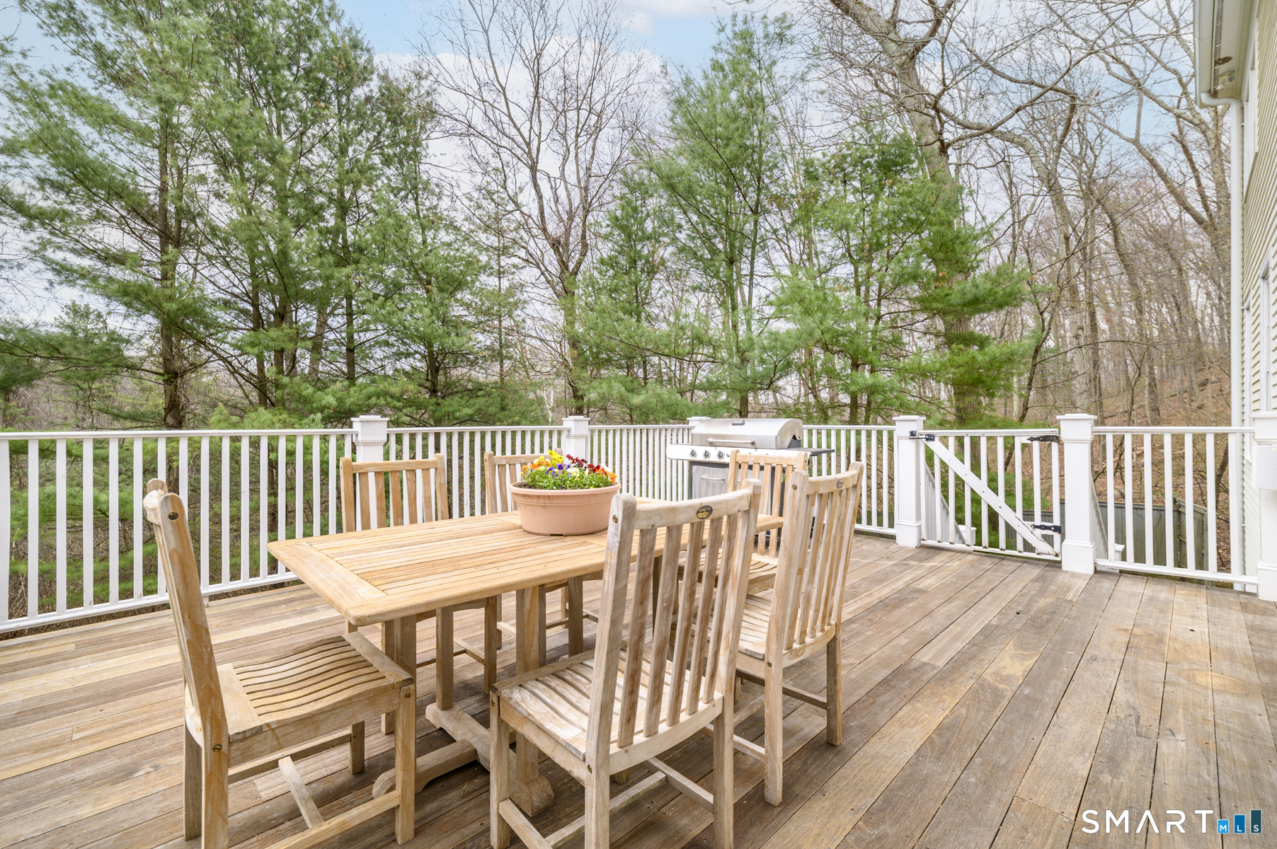 53 Wolfpit Road Wilton, CT 06897 - Photo 36 of 40 a view of a wooden chairs and table on the deck
