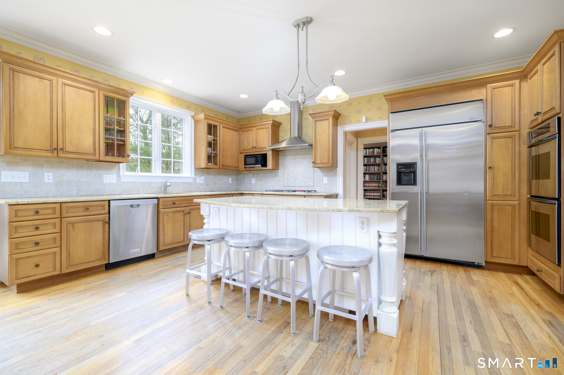 53 Wolfpit Road Wilton, CT 06897 - Photo 9 of 40 a kitchen with stainless steel appliances a dining table chairs stove and refrigerator