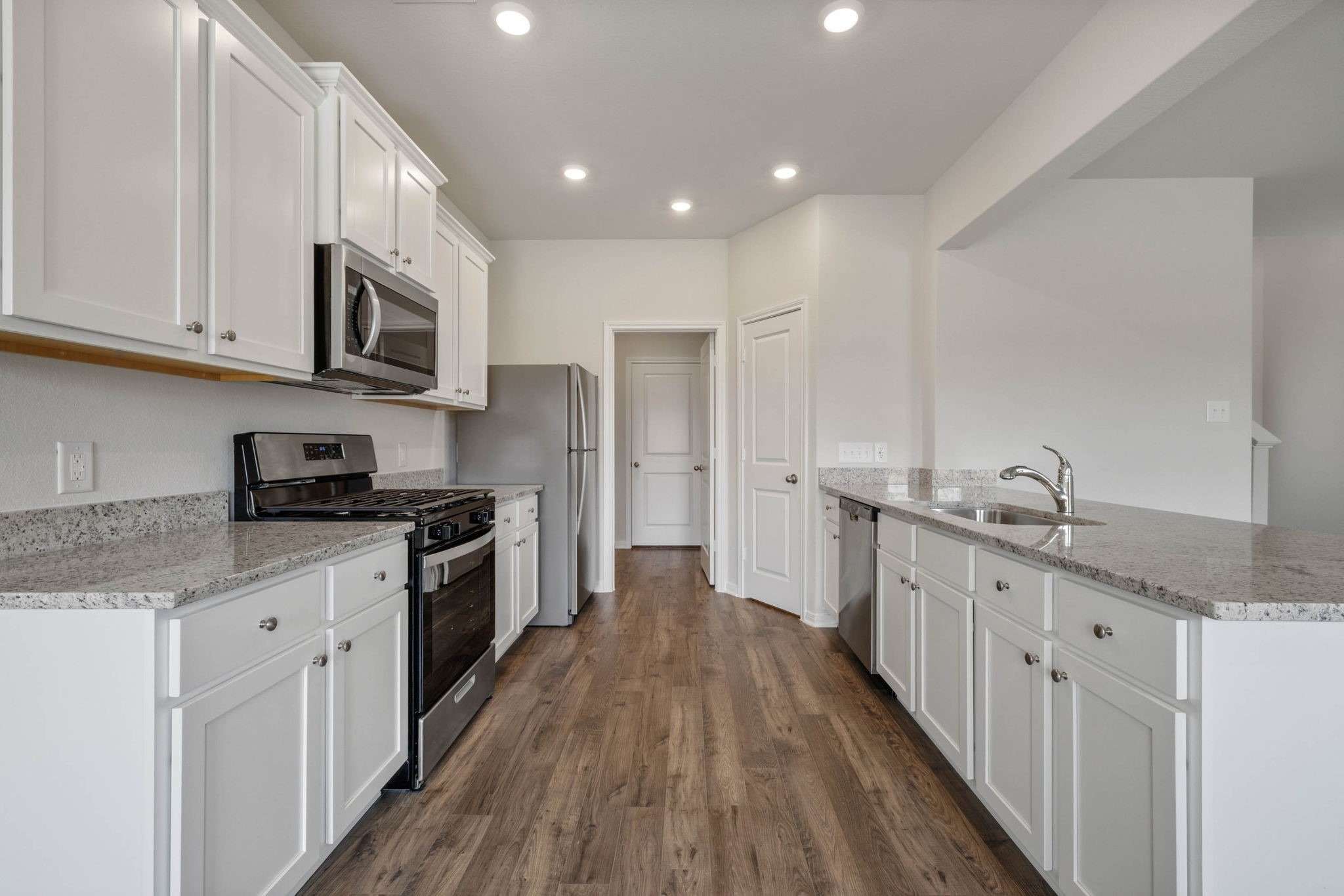 10339 Red Cardinal Drive Cleveland, TX 77328 - Photo 12 of 27 a large kitchen with stainless steel appliances granite countertop a lot of counter space and wooden floor