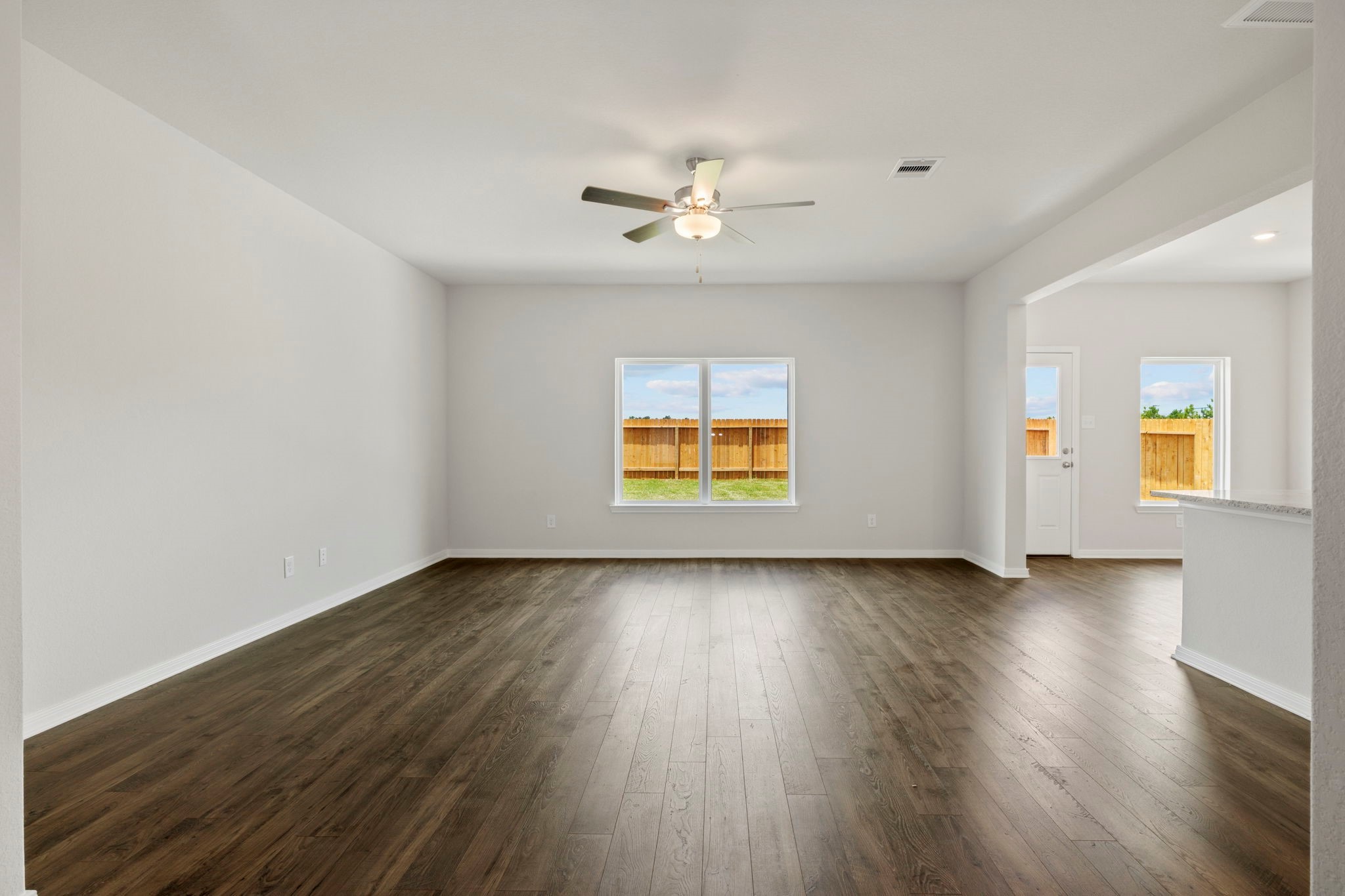 10339 Red Cardinal Drive Cleveland, TX 77328 - Photo 8 of 27 an empty room with wooden floor ceiling fan and windows