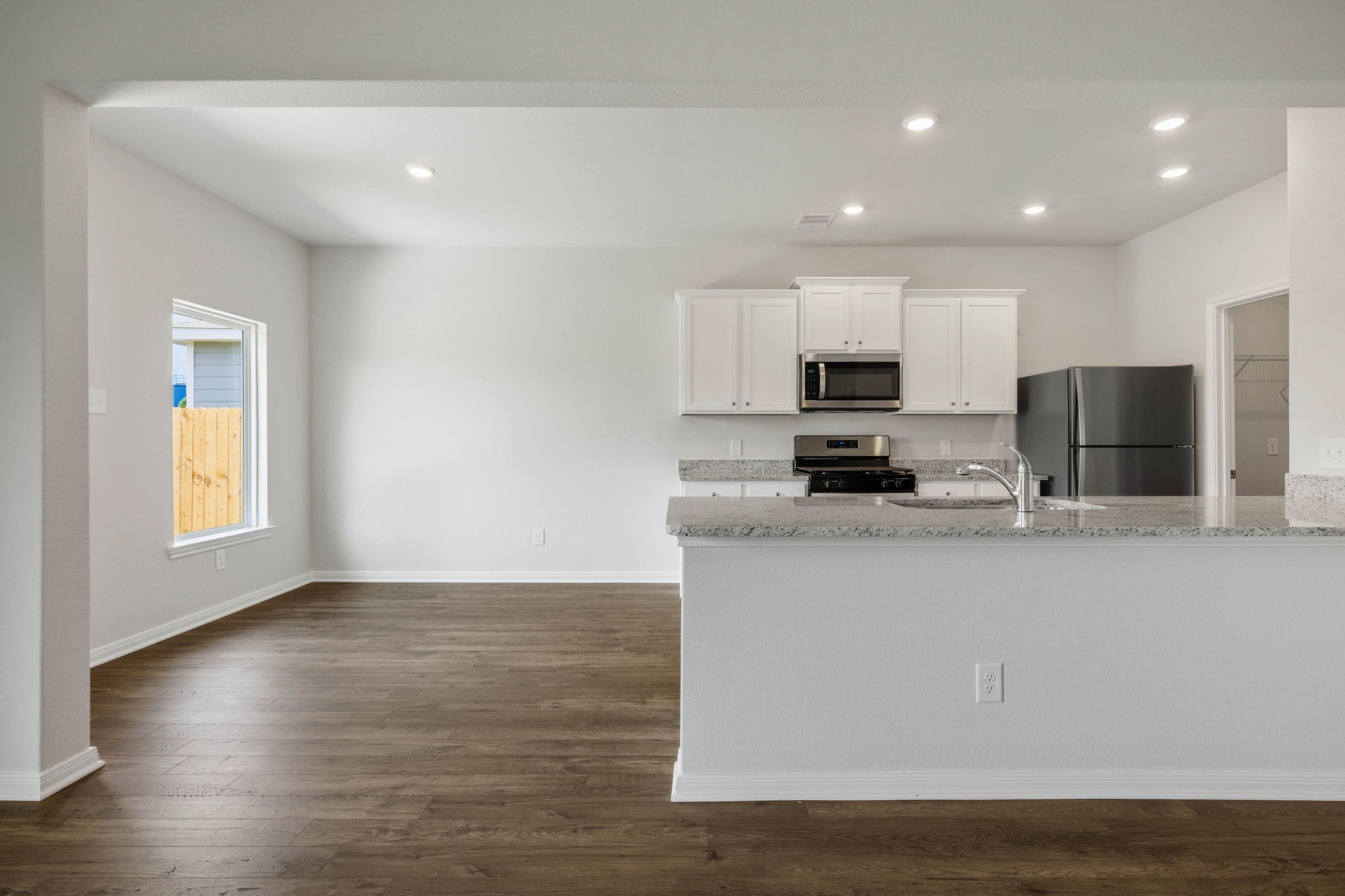 10339 Red Cardinal Drive Cleveland, TX 77328 - Photo 10 of 27 a kitchen with stainless steel appliances granite countertop a stove a sink a refrigerator and a microwave
