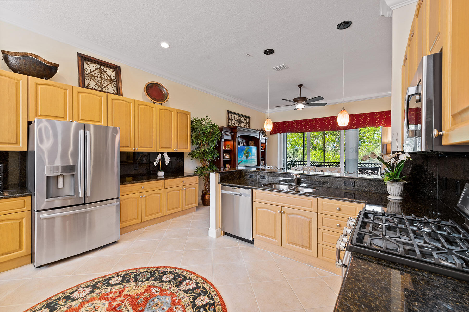 9259 Museo Circle, Unit 203 Naples, FL 34114 - Photo 7 of 46 a kitchen with stainless steel appliances granite countertop a stove a sink and a refrigerator
