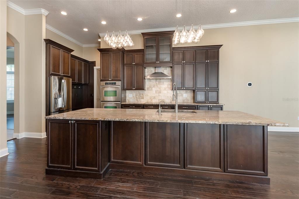 5331 Vista Club Run Sanford, FL 32771 - Photo 15 of 53 a kitchen with kitchen island granite countertop wooden cabinets and refrigerator