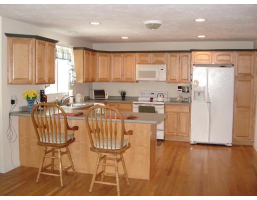 39 Shaker Road Shirley, MA 01464 - Photo 4 of 15 a kitchen with stainless steel appliances a refrigerator a sink a stove a table and chairs