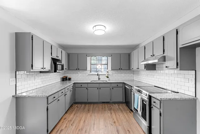 a kitchen with a sink stove cabinets and refrigerator