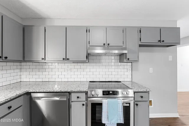 a kitchen with stainless steel appliances granite countertop a stove and a sink
