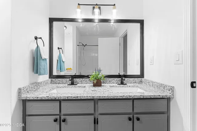 a bathroom with sinks granite and a mirror