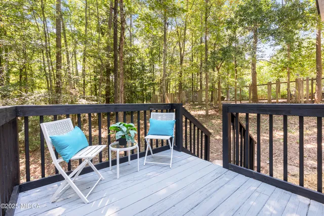 a view of a balcony with chairs and wooden floor