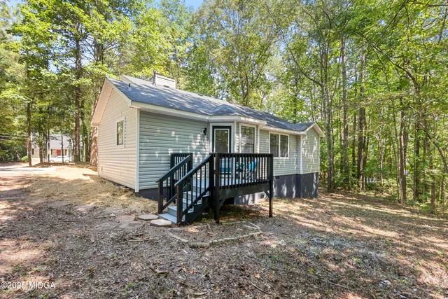 a view of house with a yard and seating area