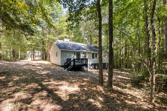 a view of a house with large trees and a barn