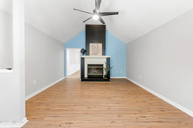 a view of empty room with wooden floor and fireplace