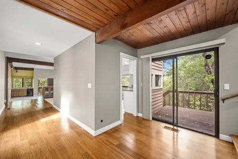a view of an empty room with window and fire place