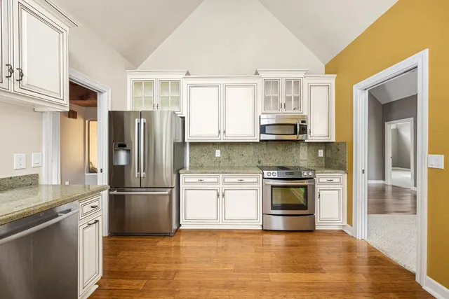 a large kitchen with kitchen island a large counter space a sink stainless steel appliances and cabinets
