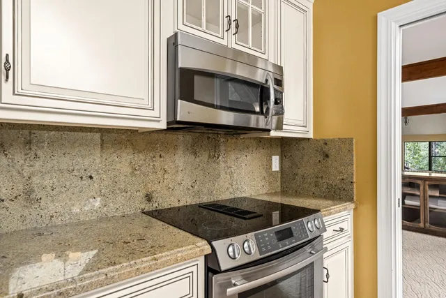 a view of an empty room with wooden floor and windows