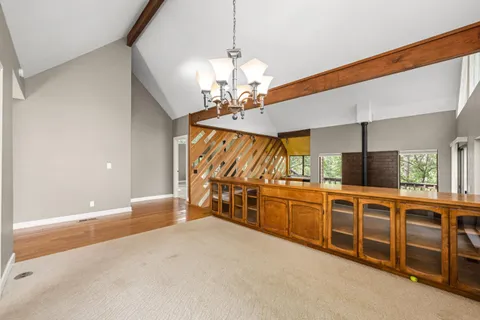 a view of an empty room with window and a kitchen