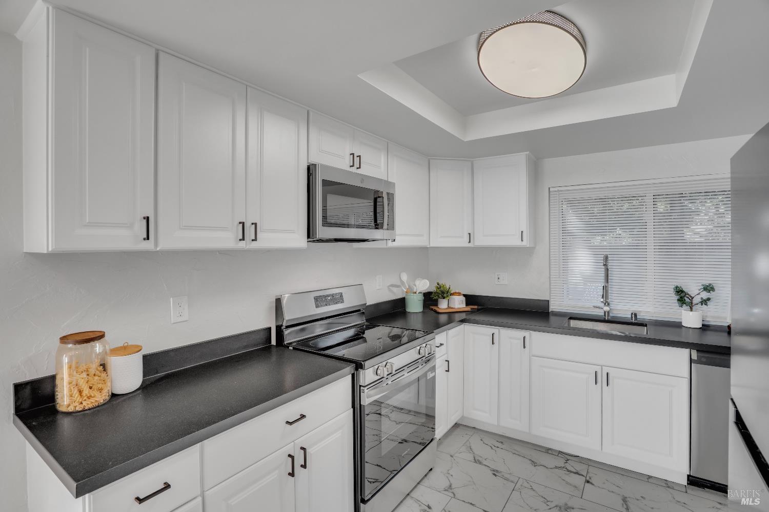 2785 Canyon Creek Drive San Ramon, CA 94583 - Photo 13 of 36 a kitchen with white cabinets a sink dishwasher and a stove with wooden floor