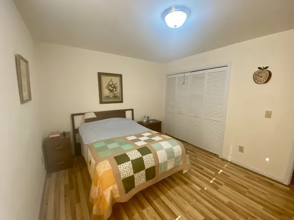 a bedroom with a bed and wooden floor