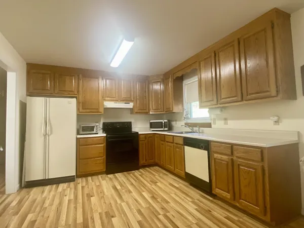 a kitchen with granite countertop stainless steel appliances and wooden cabinets