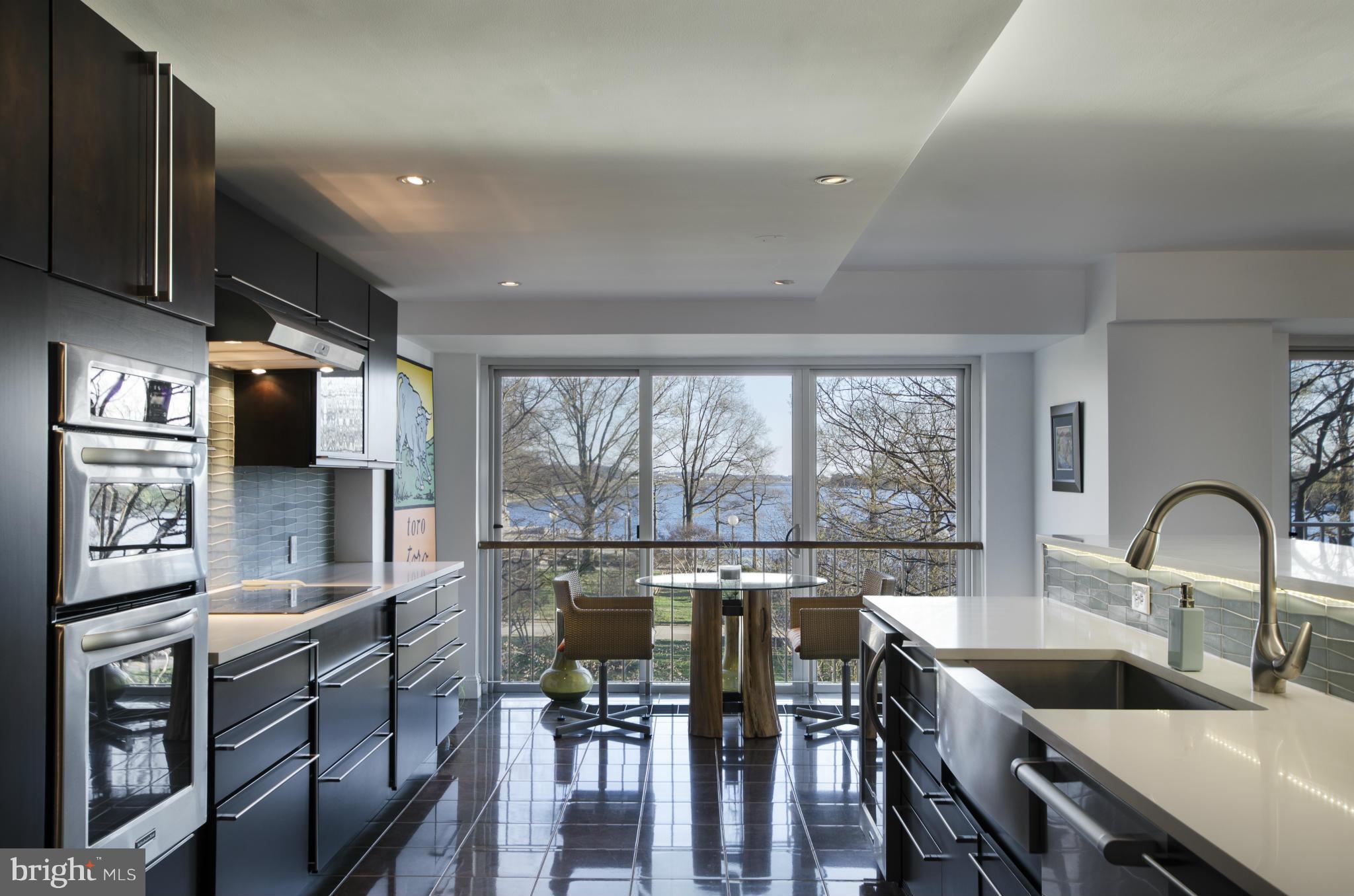 550 N Street Southwest, Unit S201 Washington, DC 20024 - Photo 4 of 30 a kitchen with granite countertop a stove a sink a dining table and chairs