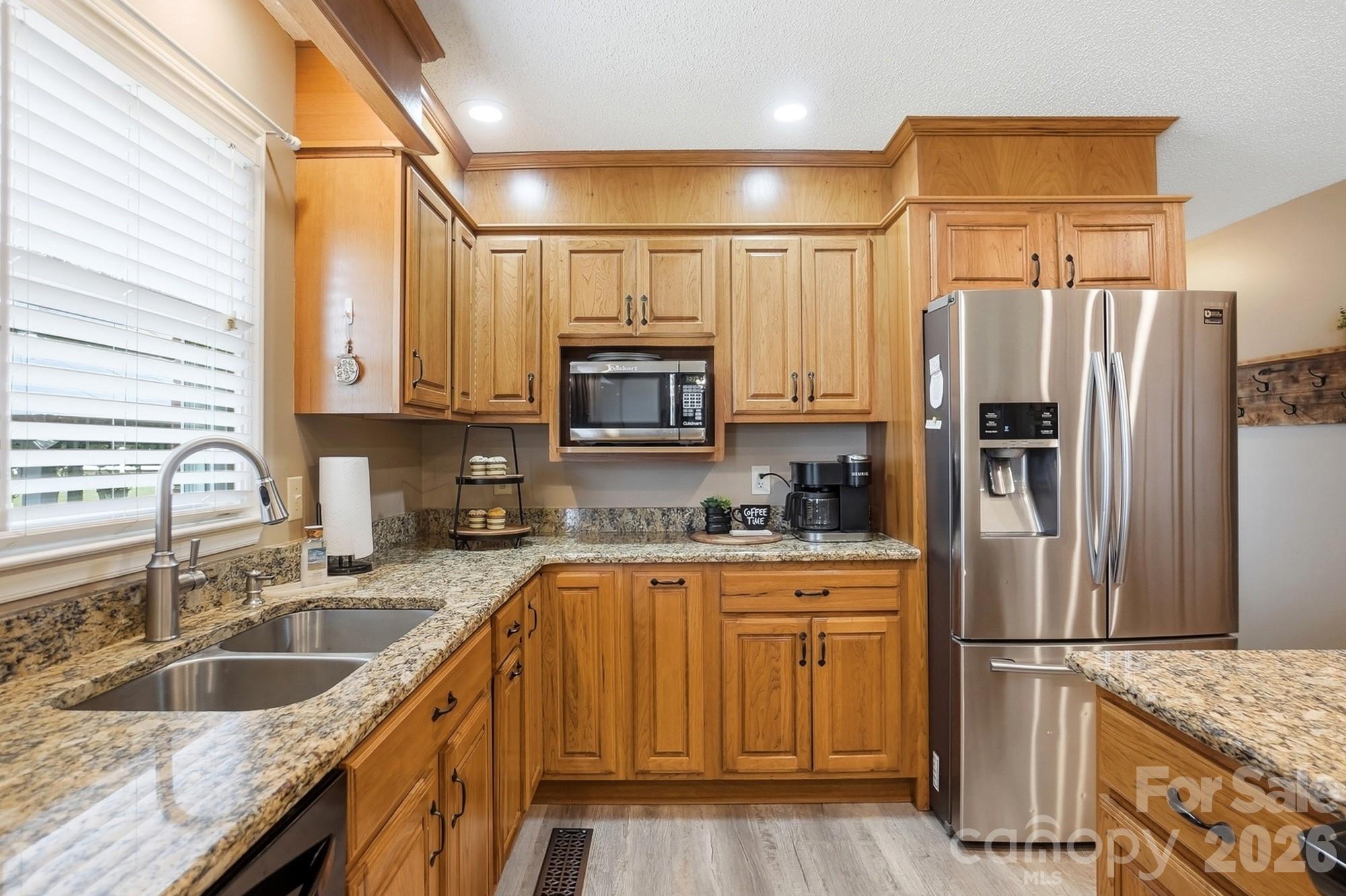 4017 Mullis Newsome Road Monroe, NC 28110 - Photo 18 of 38 a kitchen with granite countertop a sink stainless steel appliances and cabinets