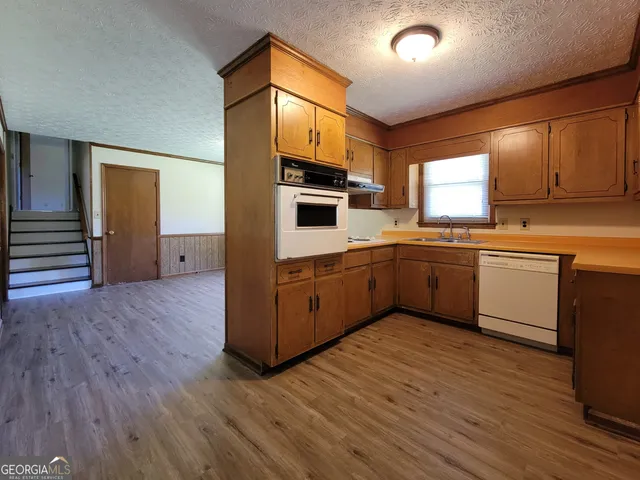 a kitchen with a sink cabinets and wooden floor