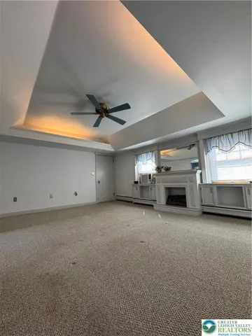 an empty room with fireplace and windows