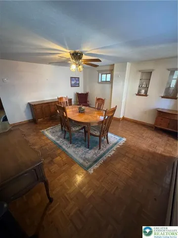 a living room with furniture a chandelier and a dining table