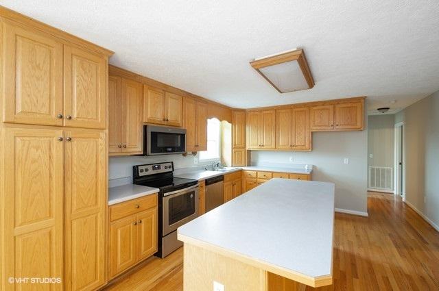 321 Pernello Road Ferrum, VA 24088 - Photo 5 of 25 a kitchen with stainless steel appliances granite countertop a stove top oven a sink a refrigerator with grey cabinets and wooden floor