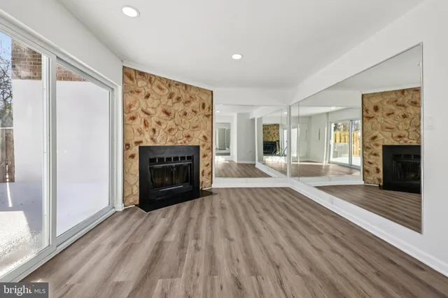 a living room with furniture a fireplace and a large window