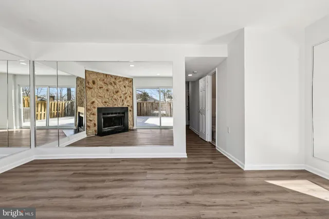 a view of empty room with fireplace and flat screen tv