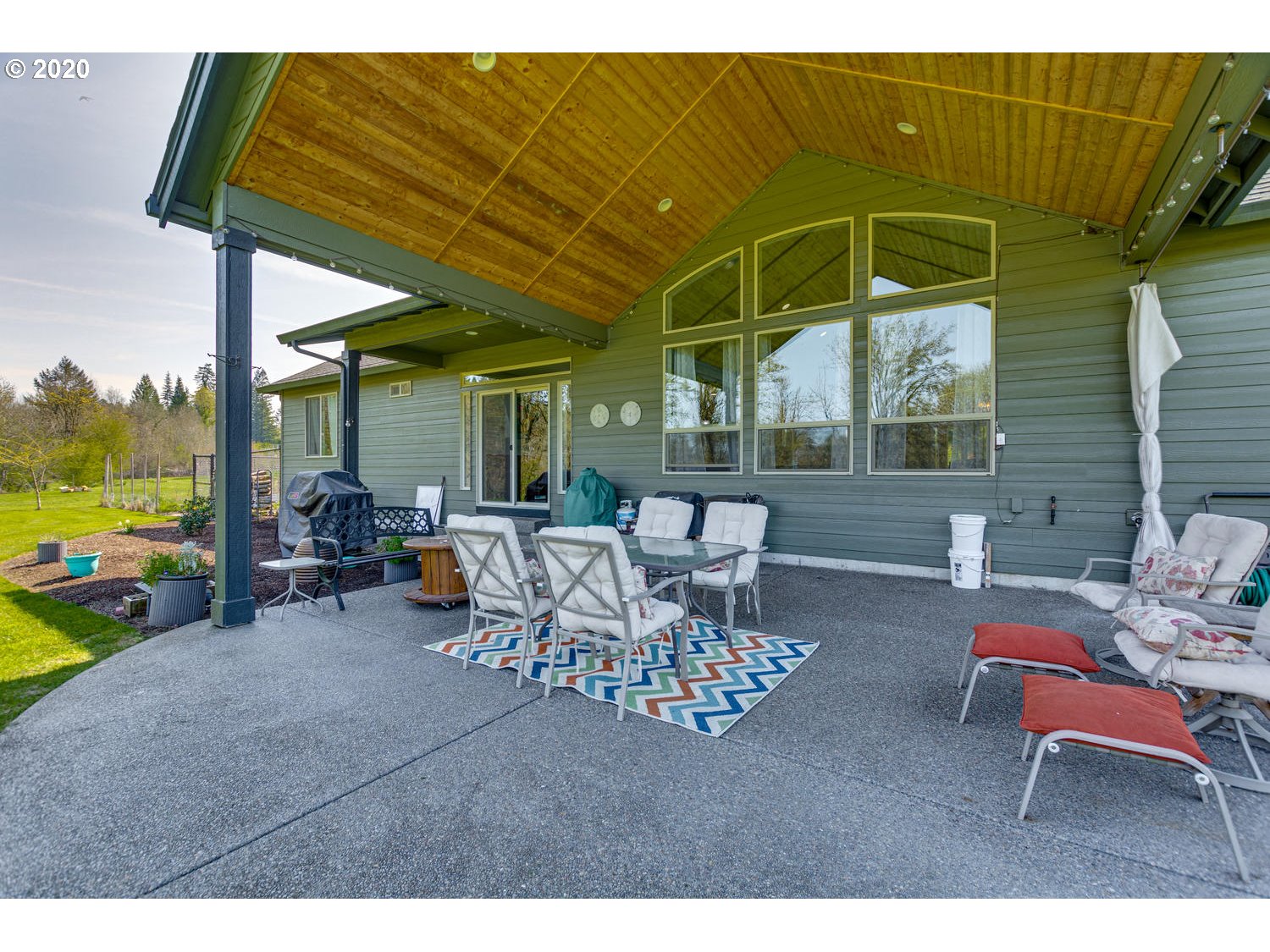 1704 Northwest 179th Street Ridgefield, WA 98642 - Photo 21 of 28 a view of a patio with a table and chairs under an umbrella