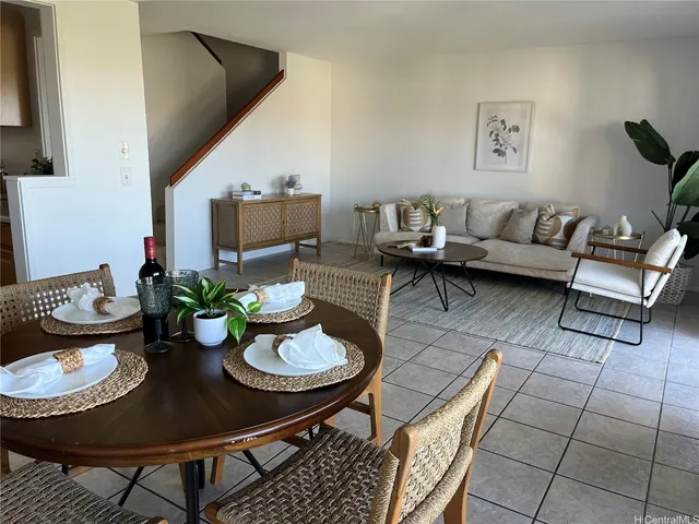 a living room with furniture and a dining table with garden view